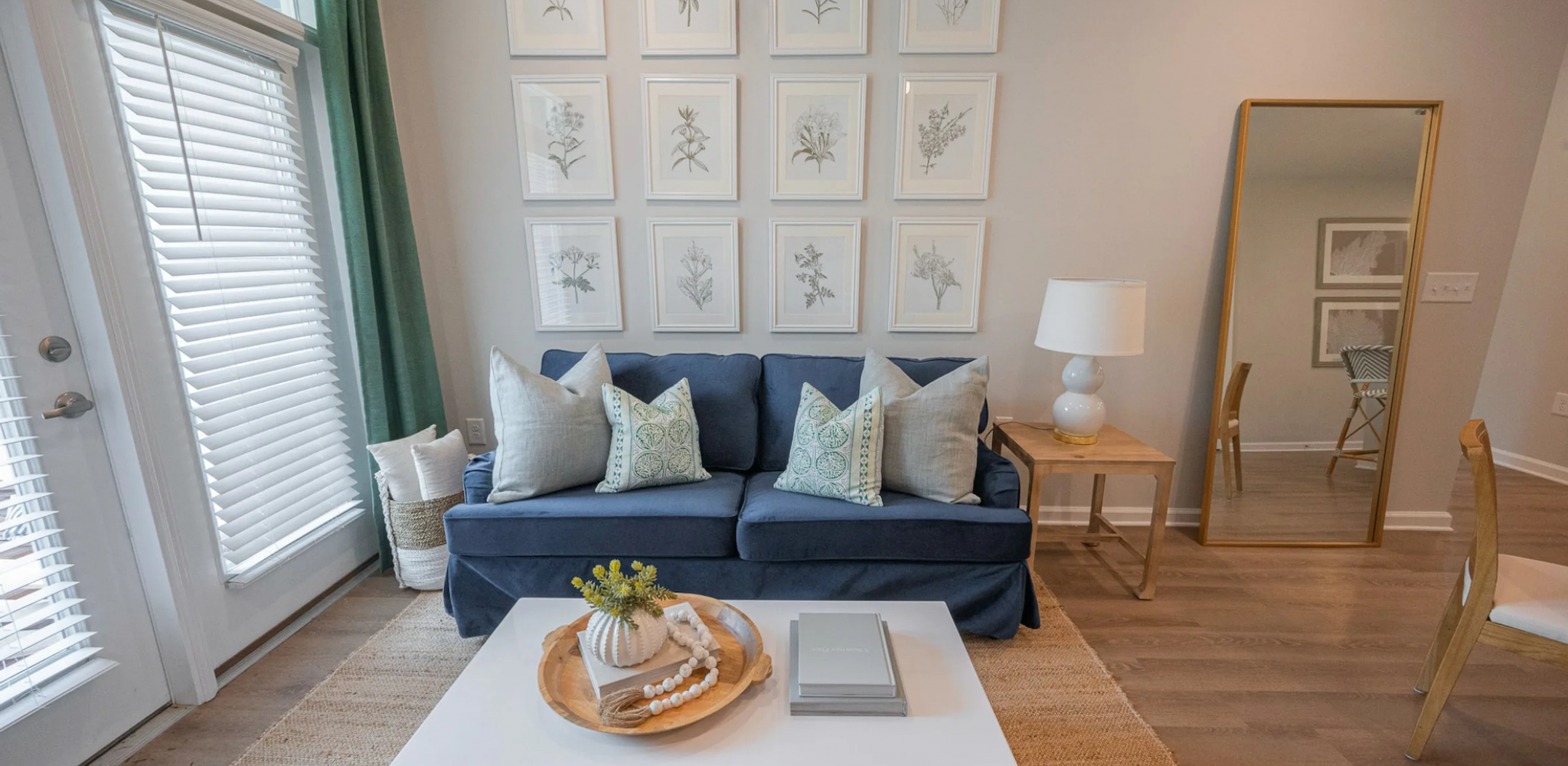 Hawthorne Waterside elegantly furnished bedroom with a striped headboard, chic bedside tables, and framed art above.